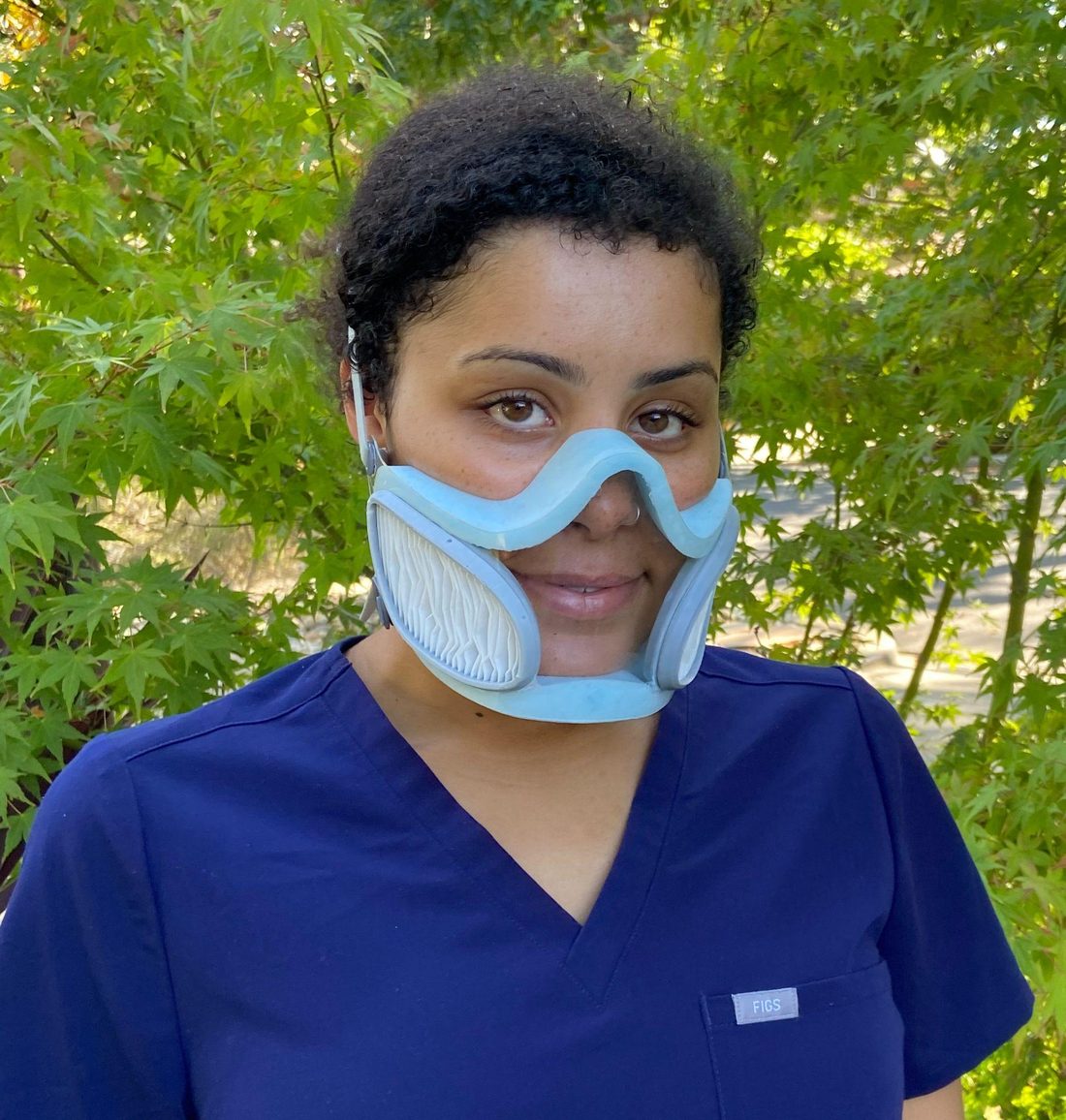 A healthcare worker wearing the ClearWorks transparent respirator, face fully visible through the clear shell